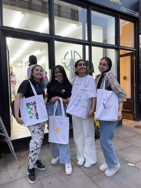 4 participants with their finished tote bags from the screen-printing workshop
