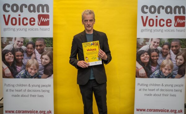 Peter Capaldi holding the Anthology at the Coram Voices Writing Awards Ceremony